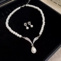 Elegant pearl jewelry set with silver V-shaped pendant and matching stud earrings - Pearl Necklace with V-Shape Diamond Pendant / Silver