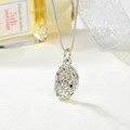 Detailed close-up of a silver pebble-shaped pendant with multi-colored gemstones on a box chain - Silver Oval
