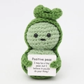 Handmade knitted positive green peas doll holding an encouraging quote card on white background - Pea Baby