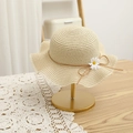 Detail of a beige straw sun hat with wavy brim and daisy flower on a gold stand - 54cm / Hat / Beige