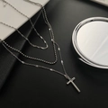 Silver triple-layered necklace featuring a cross pendant and beaded chain detail - Silver