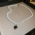 Detailed macro view of heart pendant with black center and silver trim on pearl necklace - 40# Necklace-Heart Pendant (HN4646) / Pearl White