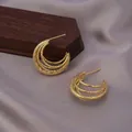 Three-layer interwoven gold earrings with a vintage textured finish on dark wood - Multi-Layer Intertwined C-Shape / E-060---Gold