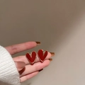 Dettaglio degli orecchini a cuore irregolari in smalto rosso con bordo dorato - Perno in Argento Cuore-Rosso