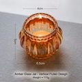 Amber glass candle holder with vertical ribbing, including a burning tea light candle - Vertical Stripe / Amber