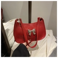 Vue détaillée d'un sac à main en cuir verni rouge brillant avec un nœud argenté - Rouge
