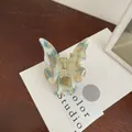 Butterfly hair claw clip with marble texture in cream and blue on a display card - Marble