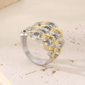 Close-up of wavy gold and silver steel ring with micro zircons on limestone base - US 7 / Wave Woven Bicolor Ring (KR108578-K)