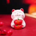 Cute white Maneki Neko figurine holding red persimmons with Ping An message - Persimmon Peace Cat