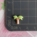 Vue macro d'un mini palmier en résine de 1,5 cm sur une règle graduée pour la taille - Deux Cocotiers avec Quatre Feuilles
