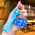Detail of blue heart-shaped quicksand keychain with star sequins and Fairy Tales strap - Blue Bow With Glow-in-the-dark Bubble Beads And Heart Shape