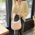 Bolso acolchado con degradado rosa llevado por una modelo en una cafetería - Arcoíris Acolchado Mediano