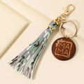 Detail of keychain with green camouflage leather tassel and wooden MAMA charm - Camouflage