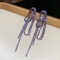 Dettaglio di orecchini argentati con strass viola e lunghe nappe su un vassoio elegante - Stile Nappina Viola con Maglie di Catena / Canna di Fucile
