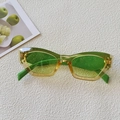 Close-up of green gradient cat-eye sunglasses with glitter lenses on a white background - Sparkle Green