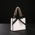White gift bag with black trim and ribbon featuring gold metallic woven handles - White Bag Black Border + Black Ribbon