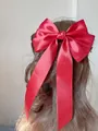 Large red satin bow hair clip with long ribbons on wavy brown hair - Burgundy