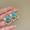 Detailed macro view of vintage turquoise earrings with white flowers and pearl tassels - 68# Silver Pin - Gold Blue Studs