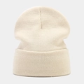 Detailed close-up of ribbed texture and beige knit fabric on winter beanie hat - Beige