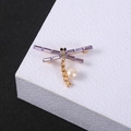 Golden dragonfly brooch with purple crystal wings and a white pearl on white stand - Dragonfly