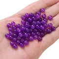 Polished round purple glass jelly beads for DIY jewelry making shown in hand - Purple approx 50pcs/pack