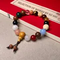 Macro shot of 18 colorful assorted Buddhist beads with a decorative tassel and gourd - Premium Style (Tiger Eye)
