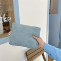 Blue corduroy makeup bag with striped texture held by hand in a minimalist cafe setting - Light Blue