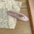 Primer plano de una pinza para el cabello ovalada de acetato rosa sobre papel vintage - Rayado rosa