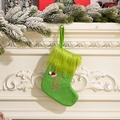 Calcetín navideño de punto verde con letra E dorada brillante colgado en una chimenea - Letra E