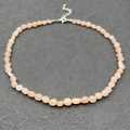 Macro shot of natural irregular rose quartz beads necklace with adjustable steel clasp - Pink Aventurine
