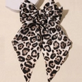 Elegant leopard print bow spring clip with brown and black patterns on beige background - Grey Leopard Print