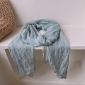 Detail of light grayish green pleated scarf draped over white stone stand with woven bag - 180*90CM / Sky Blue