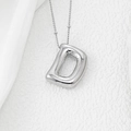 Macro shot of a silver D-shaped balloon pendant necklace with realistic fold details - Letter D Pendant