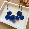Nahaufnahme der blauen Kunstharz-Blütenanhänger an einer braunen Lederkordel - Blaue Blume/Kaffeeseil