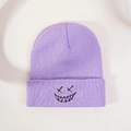 Close-up of purple ribbed knit beanie featuring black embroidered grimace face pattern - One Size / Light Purple