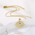 Goldene Evil Eye Halskette mit klaren Zirkonia und blauem Stein auf Marmortablett - Gold