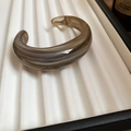 Detailopname van een brede acryl manchetarmband met bruine marmertextuur op tray - Grijs marmerpatroon