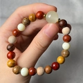 Close-up of a multi-color beaded bracelet with lion carving and wooden bamboo texture - Luminous Bead Style