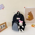 Cute black canvas kids backpack with checkered front pocket and white plush bunny toy - Black