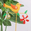 Dettaglio ravvicinato di uccellino giallo e fiore rosso su picchetto da giardino - Girandola a Uccello Giallo
