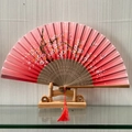 Chinese style folding fan with gradient pink cherry blossoms and a red tassel - Spring Breeze in the Hall (Brown)