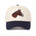 Dettaglio del ricamo a cavallo su un cappellino in cotone crema e blu scuro - Blu Notte