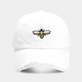 Détail de la broderie d'abeille jaune et des trous usés sur la casquette blanche - Réglable / Blanc