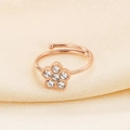 Close-up of rose gold cat paw ring with flower zircon inlay on soft fabric background - US 6
