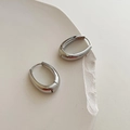 Minimalist silver oval hoop earrings on cream plaster tray with elegant mirror finish - Silver