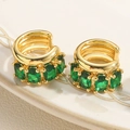 Detalle de pendientes de aro dorados con circón esmeralda óvalo y bandas de metal de capas - Earcuff Dorado de Triple Capa con Circonita Esmeralda
