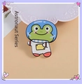Cute green frog astronaut enamel pin on a decorative white lace background - Astronaut Frog
