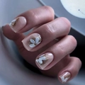Makroaufnahme von Nude-French-Nägeln mit weißen Blumen und goldenem Glitzer auf kurzen Tips - Französischer weißer floraler Goldglitzer-Stil (LC26) / Gelee-Kleber Werkzeugset (24 Stück/Packung)