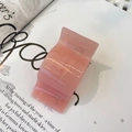 Translucent pink acrylic hair claw clip with water ripple texture on an open magazine - Strawberry Jelly Pink