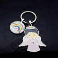 Detail of metal rainbow keychain with Schulkind text and guardian angel charm on dark surface - Light Purple